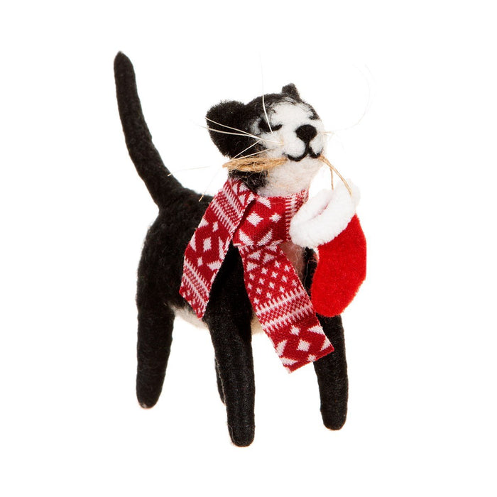 Black-and-white felt cat Christmas decoration wearing a patterned red scarf and carrying a small red stocking, cut-out on a white background.