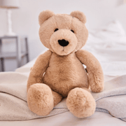 Charlie Bear classic brown plush teddy displayed in a cosy bedroom