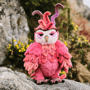 Charlie Bears Jinzi limited edition phoenix plush displayed outdoors on a stone wall, showing colourful layered plumage