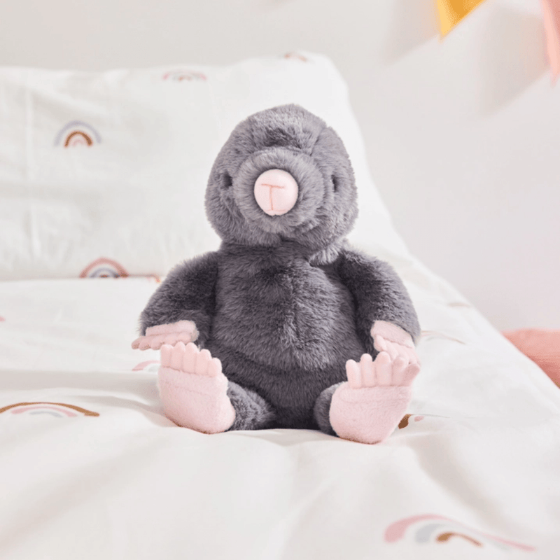 Charlie Bears Mula Mole grey plush soft toy sitting on a child’s bed
