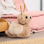 Charlie Bears Saffy Snail plush soft toy displayed in a cosy bedroom