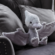 Charlie Bears Wings Pterodactyl cloudy-grey plush soft toy sitting on a sofa