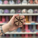 Brown segmented Chocolate Hazelnut Praline wax melt held in hand in front of a colourful wax melt shelf