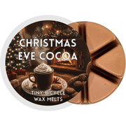 Christmas Eve Cocoa brown segmented wax melt pot with mug of hot chocolate by a fireplace and Christmas tree