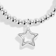 Close‑up detail of open‑star silver charm on children’s beaded bracelet
