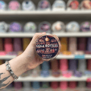 Cola Bottles wax melt pot held in hand with colourful wax melts softly blurred behind