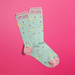 Overlapped mint women’s crew socks with pink accents, cloud and star print, cheeky Come Back With A Warrant text at cuff.