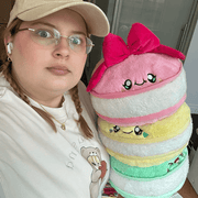 Person holding the Comfort Food Macarons plush toy for size comparison