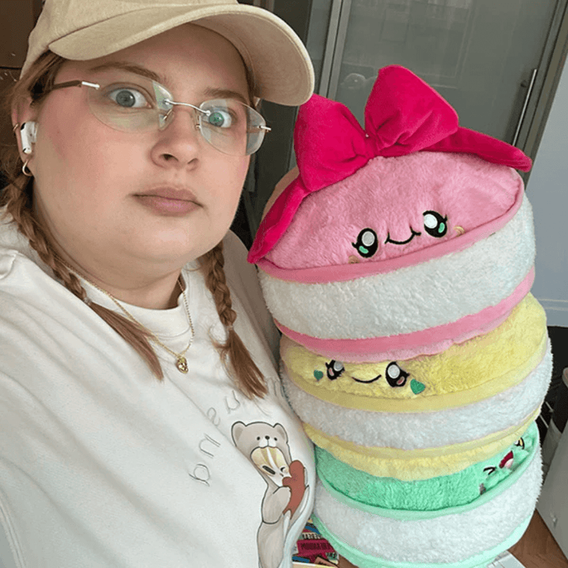 Person holding the Comfort Food Macarons plush toy for size comparison