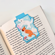 Cosy Dogs magnetic bookmark clipped securely over the page of an open book