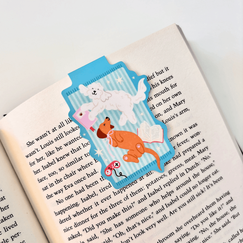 Cosy Dogs magnetic bookmark clipped securely over the page of an open book