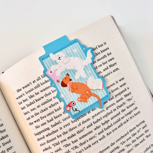 Cosy Dogs magnetic bookmark clipped securely over the page of an open book