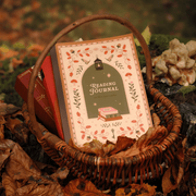 Cosy Season Reading Journal styled in a basket with autumn leaves