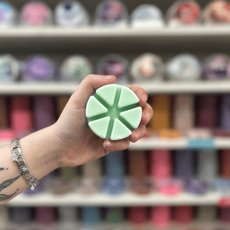 Crisp Pear and Cedarwood pale green segmented wax melt held in hand