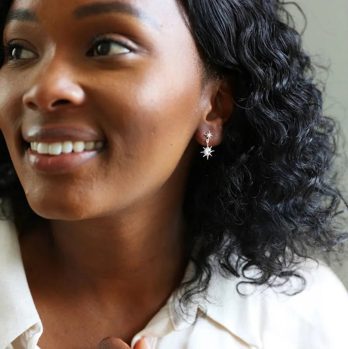 Model wearing dainty silver double star drop earrings for a subtle celestial sparkle.