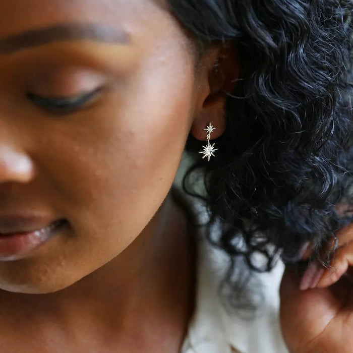 Side view of silver double star drop earrings catching the light for elegant shine.