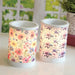 Two electric wax melt burners glowing in a styled setting, showing the floral patterns illuminated.