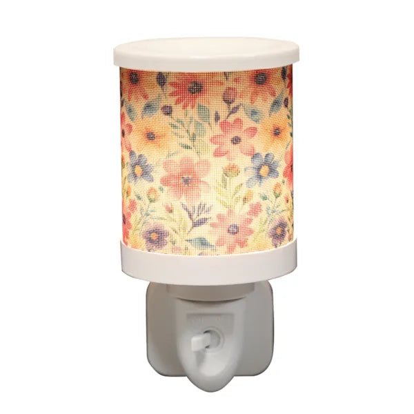 Daisy floral plug in wax melt burner switched on, glowing warmly through the floral design.