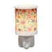 Daisy floral plug in wax melt burner switched on, glowing warmly through the floral design.