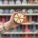 Daisy wax melt segments held in hand with colourful wax melt display in the background