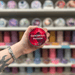 Dangerous Passion wax melt pot held in hand with colourful wax melt display in the background
