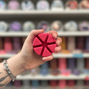 Dangerous Passion wax melt segments held in hand with colourful wax melt display in the background
