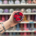 Dark Orient wax melt pot held in hand with colourful wax melt display in the background
