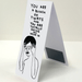 Side view of folded magnetic bookmark; hidden magnet visible and Shrigley illustration on front.
