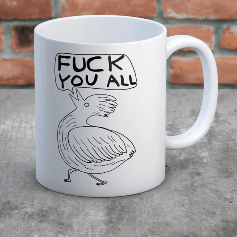 David Shrigley Fuck You All rude mug displayed against a brick background