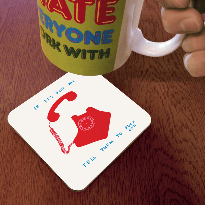 David Shrigley If It’s For Me coaster shown in use under a mug on a wooden table
