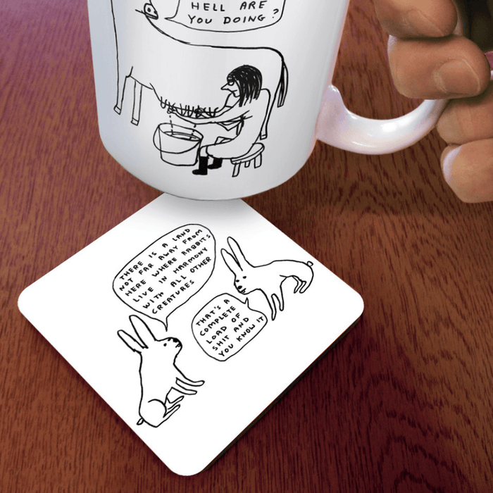 David Shrigley Live in Harmony rabbit coaster shown in use under a mug on a wooden table