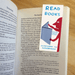 Read Books magnetic bookmark marking a page inside an open novel.
