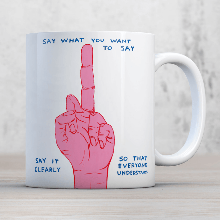 David Shrigley Say What You Want mug shown in a lifestyle setting with pink hand illustration