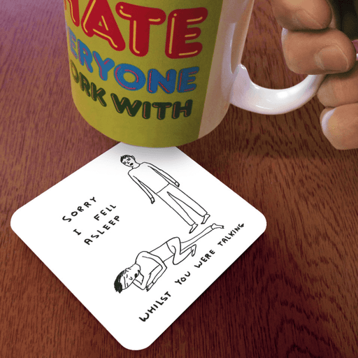 David Shrigley Sorry I Fell Asleep coaster shown under a mug on a table