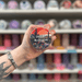 Desert Blossom wax melt pot held in hand with colourful wax melt display in the background