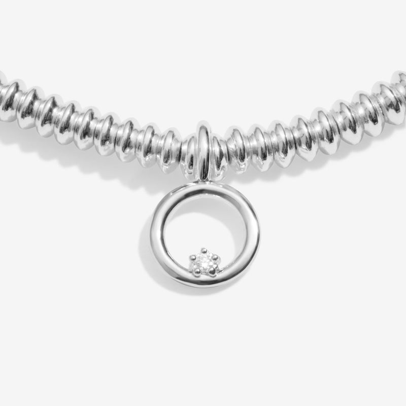“Close‑up of circular charm featuring ethical diamond accent”
