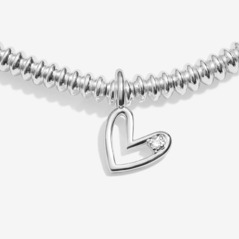 “Close‑up of open‑heart charm set with ethical diamond accent”
