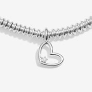 “Close‑up of open‑heart charm featuring ethical diamond accent”
