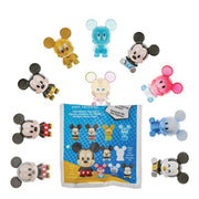 Flat lay of assorted Mickey Mouse blind bag figurines arranged around the foil packet insert.
