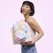 Model holding pastel pink Minnie Tie‑Dye Loungefly Back Pack bag with rainbow 3D Minnie head.	