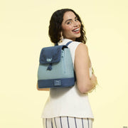 Smiling model wearing teal Disney Stitch Loungefly Back Pack bag with floral embroidery and woven texture.	