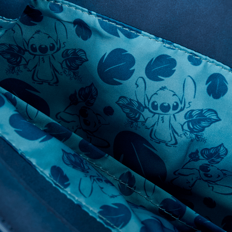 Close‑up of Loungefly Disney Stitch Back Pack bag lining featuring blue Stitch sketches and leaf motifs on satin fabric.	