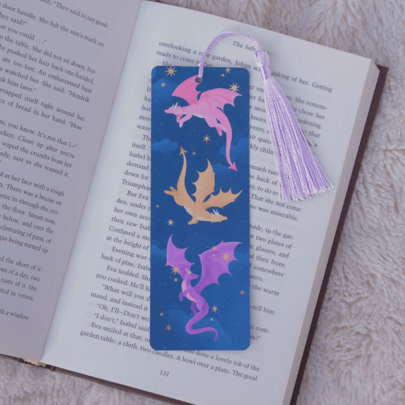 Dragons fantasy bookmark with purple tassel inside an open book