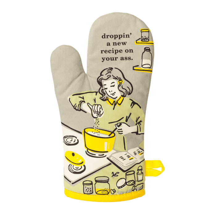 Front view of oven mitt featuring woman cooking with bold slogan and yellow accents.
