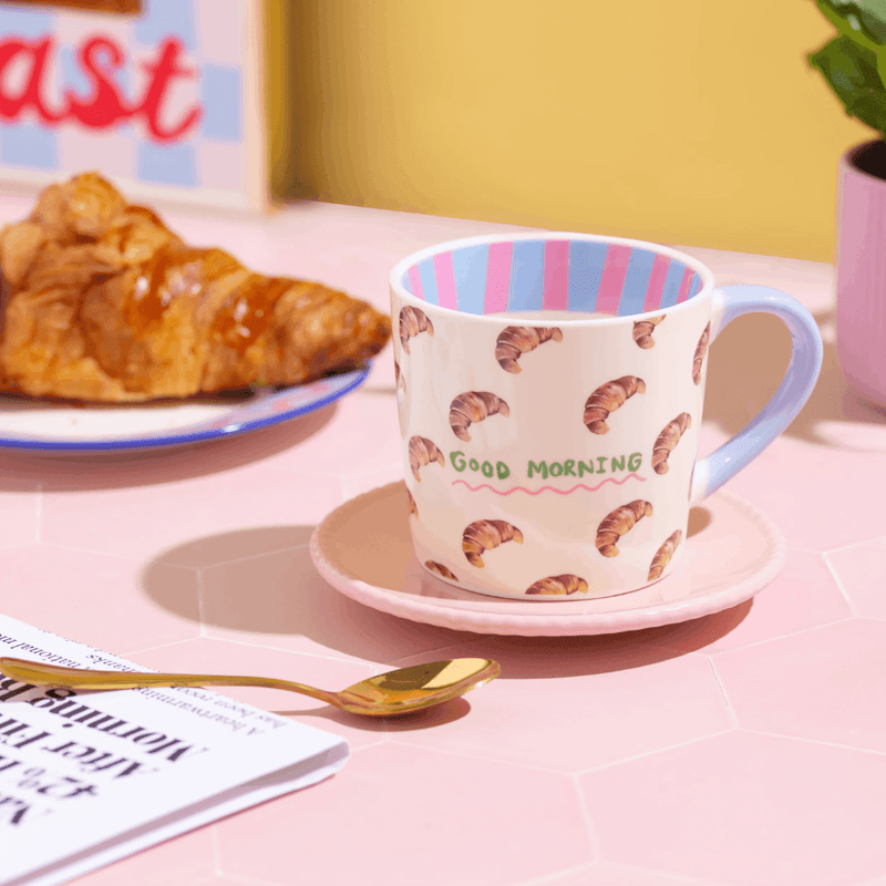 Eleanor Bowmer croissant coffee mug displayed on a pink breakfast table