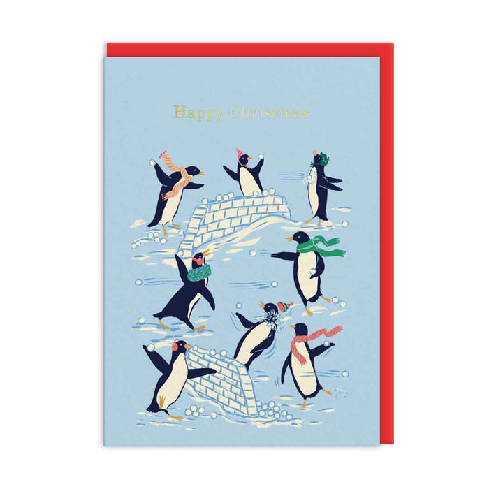 Light blue Christmas card with penguins having a snowball fight around an igloo, gold-foil Happy Christmas text; A6, blank inside, red envelope by Emily Taylor