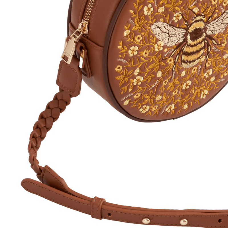 Close-up of tan faux leather plaited strap, adjustable fastening and gold-toned hardware on Fable England bag