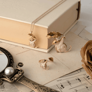 Fable England dormouse necklace displayed alongside matching woodland mouse brooch and jewellery on vintage books