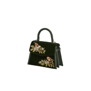 Angled view of forest-green velvet handbag showing wren embroidery, side gussets and top handle