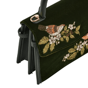 Detailed view of Fable England handbag showing embroidered wren, velvet flap and gold handle fittings